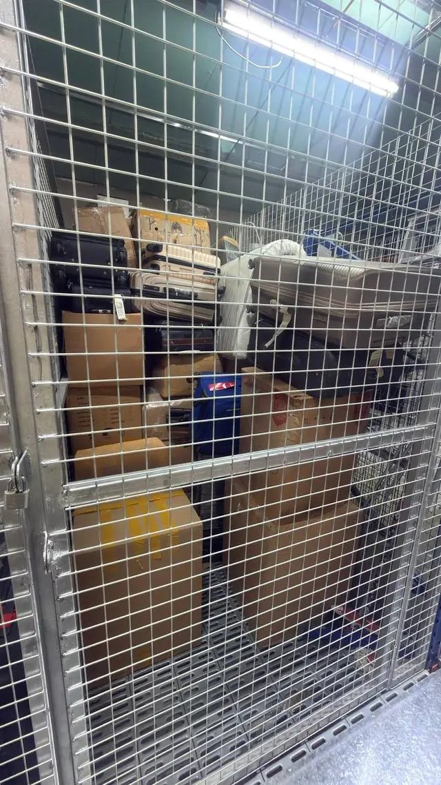 Luggage and boxes stored inside a lockable wire-mesh storage cage in Dubai