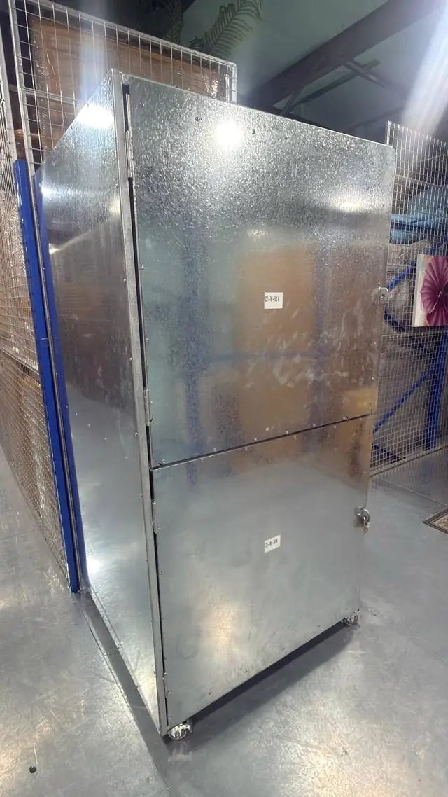Galvanised steel storage unit on wheels with a padlock in a Dubai storage warehouse