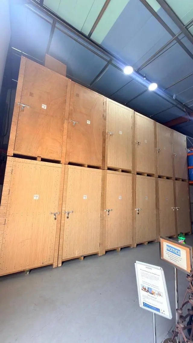 Stacked wooden storage vaults with padlocks in a QuickServe warehouse in Dubai