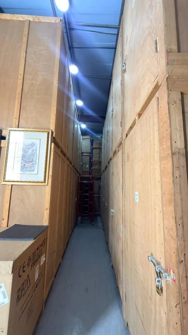 Aisle of wooden storage vaults in a QuickServe Relocations storage warehouse, Dubai