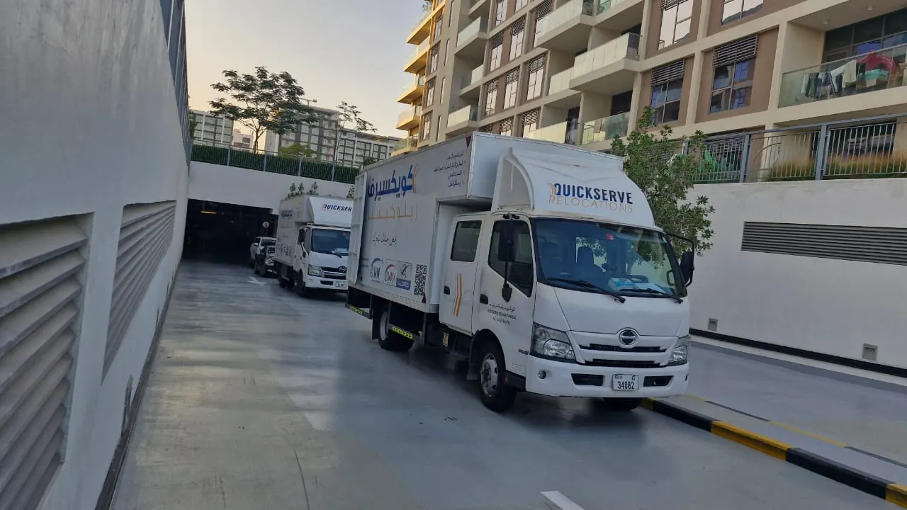 QuickServe moving trucks lined up at sunset