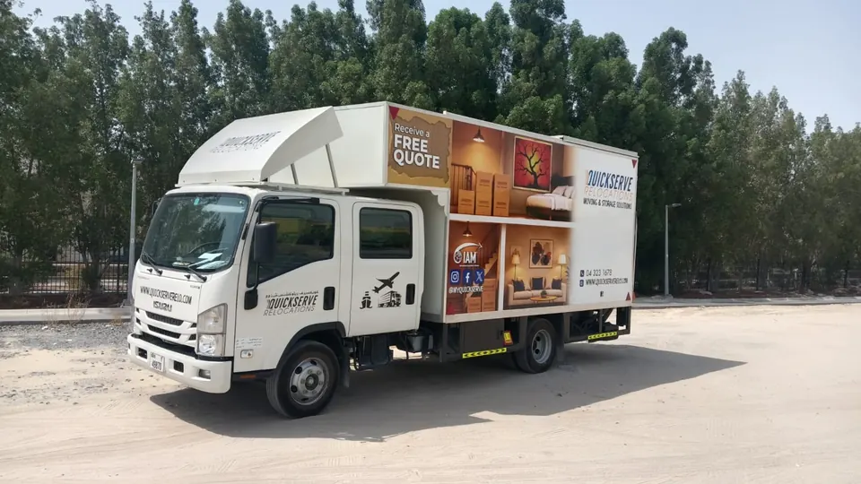 QuickServe Relocations closed-body moving truck with a free quote panel on the side, Dubai