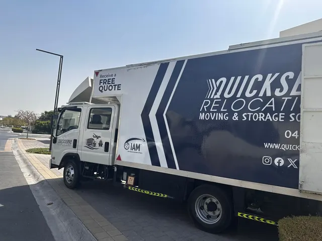Side of a QuickServe truck showing the IAM logo and contact details